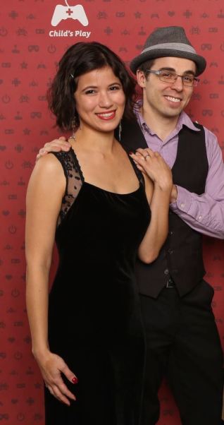 Woman wearing black velvet and lace gown and man wearing hat and gray vest at Childs Play 2014